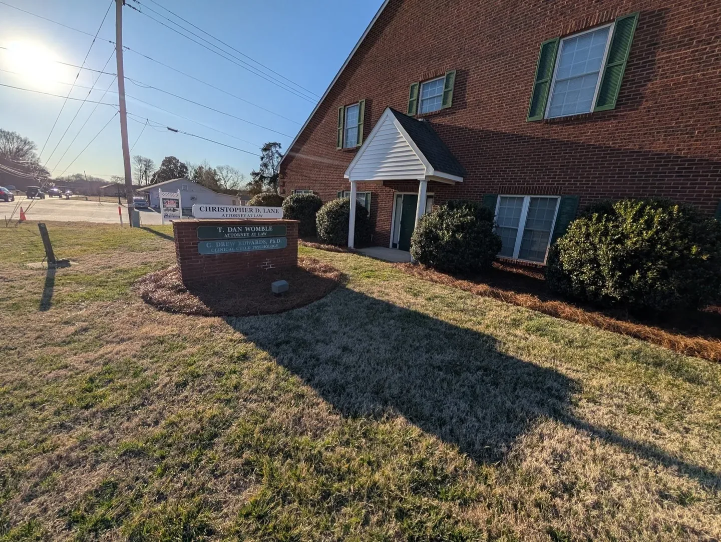 Fresh pine needles around shrubs outside an office building.