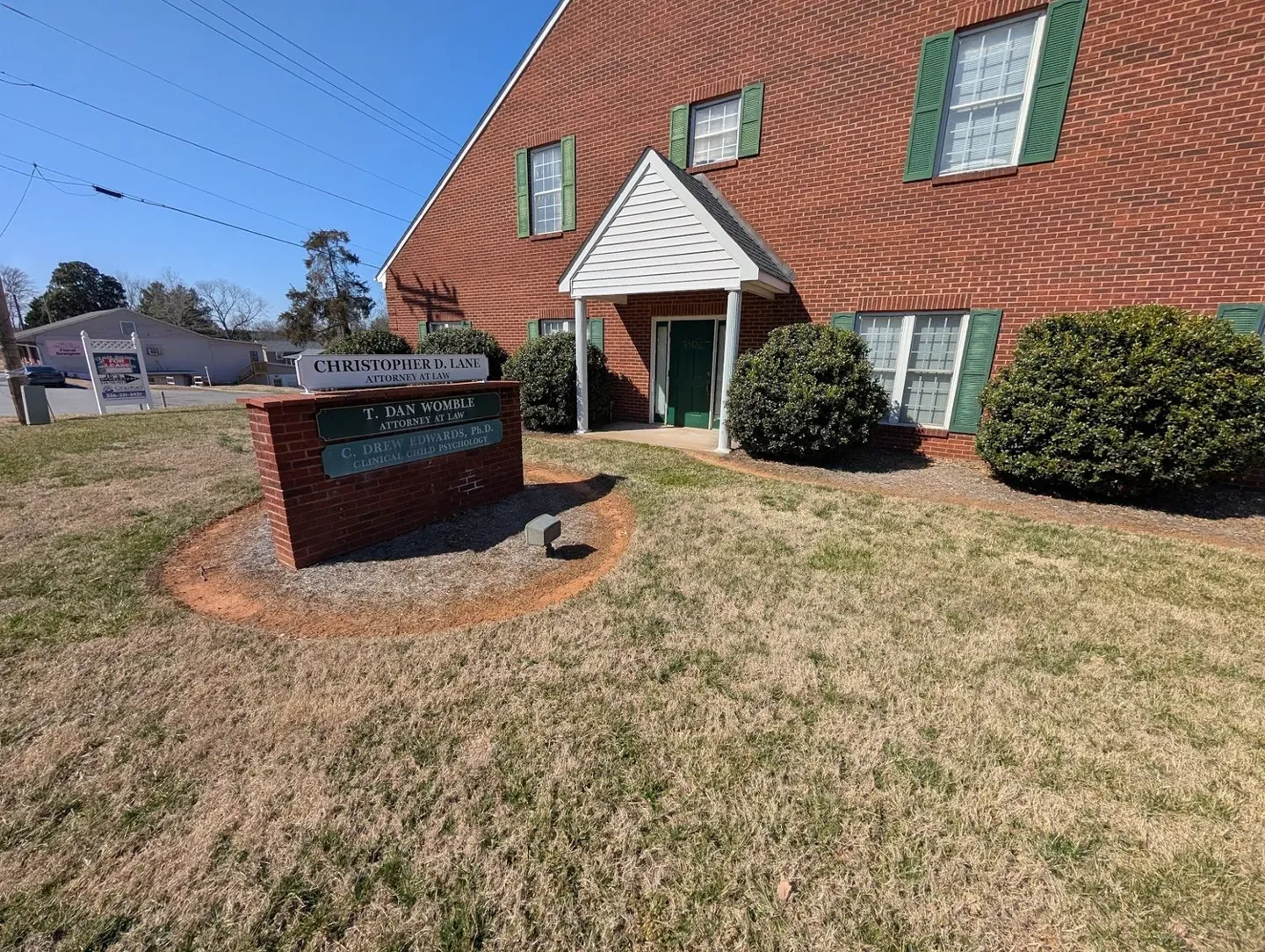 Office landscape beds with faded ground cover before pine needle installation.