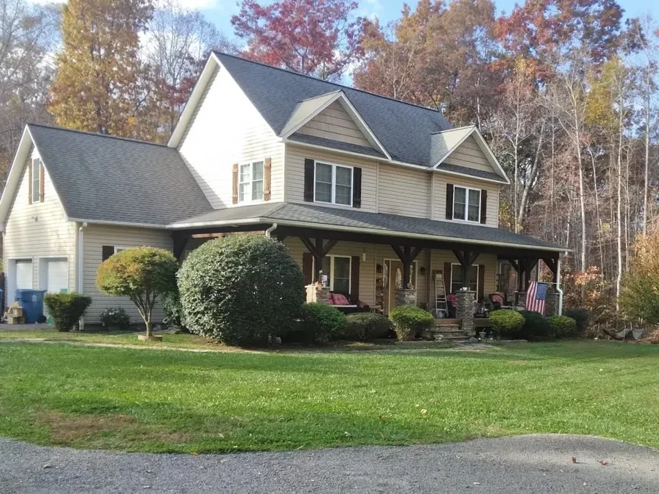 Pruned shrubs along a two-story home before new landscape edging.