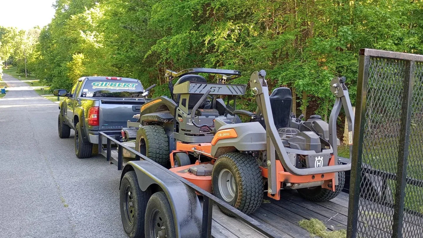 Gilbert Grounds truck and trailer carrying commercial mowing equipment.